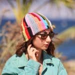 Bunte Beanie mit Quasten aus Garnresten – Upcycling